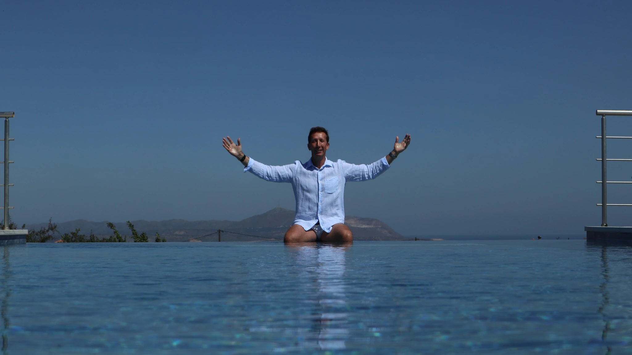 Craig Alexander Rattray sitting beside the swimming pool